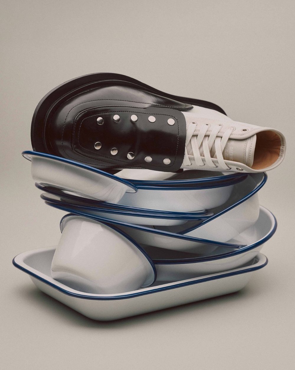 A boot balanced on a stack of enamelware dishes